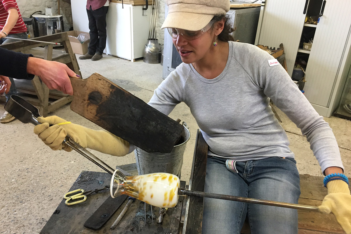 one day glassblowing course student making a glass vase on the bench