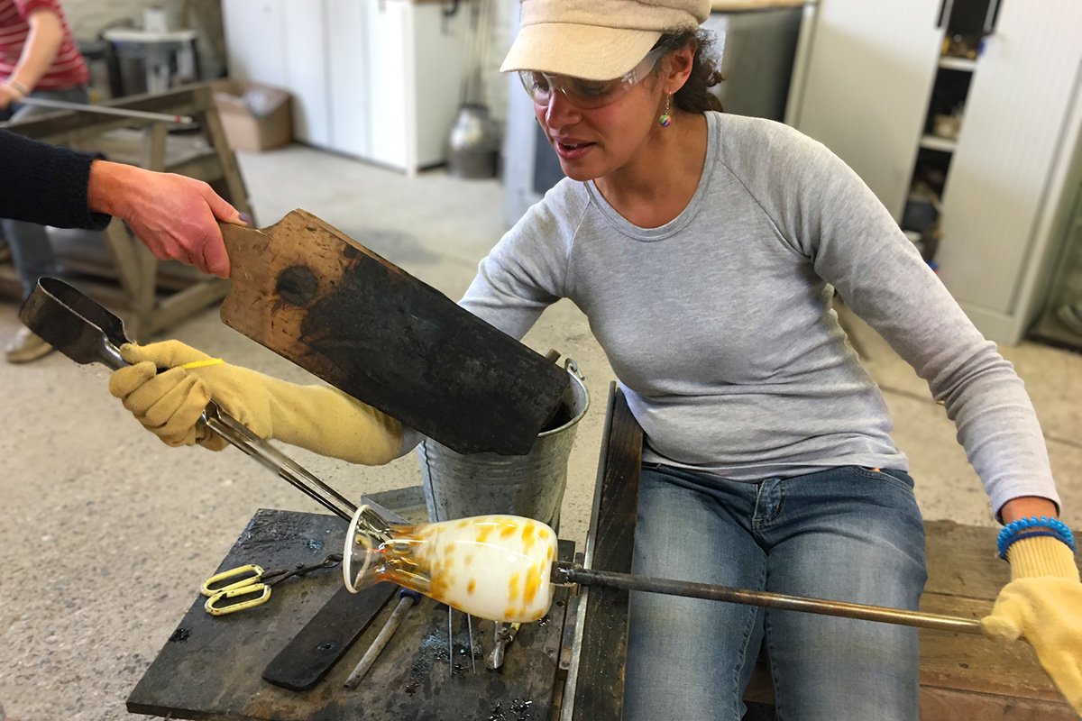 glassblowing student making a vase